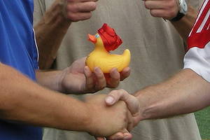 Händedruck mit Enten-Maskottchen